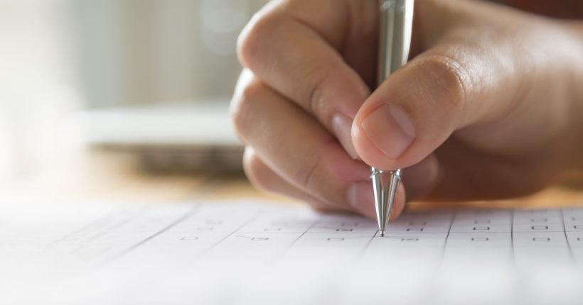 Hand with pen over application form