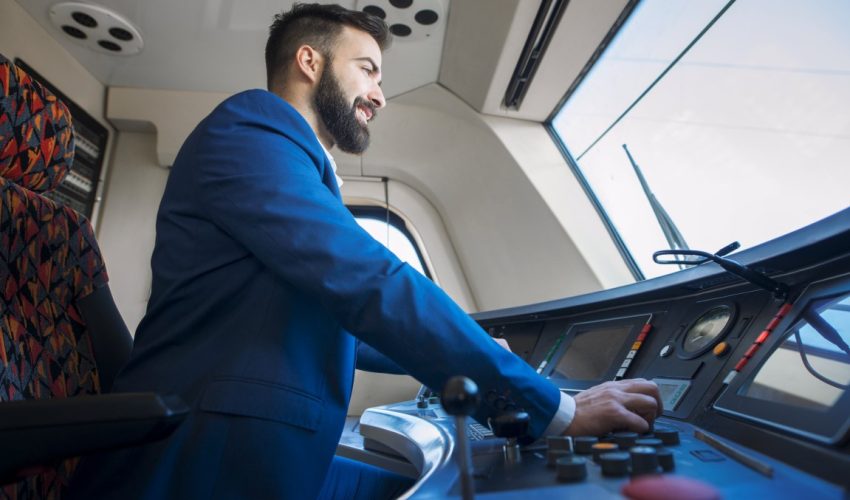 Professional driver sitting in cockpit and operating high speed train. Professional driver sitting in cockpit and operating high speed train.