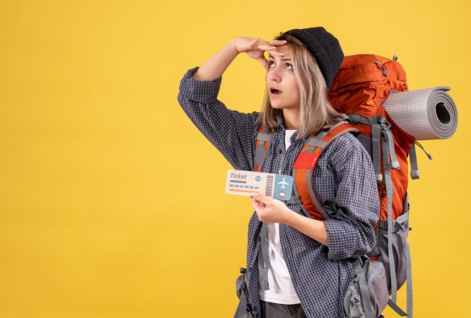 traveler-woman-with-backpack-holding-ticket-looking-up (Medium)