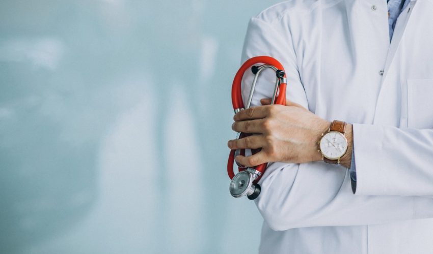 Young handsome physician in a medical robe with stethoscope Young handsome physician in a medical robe with stethoscope